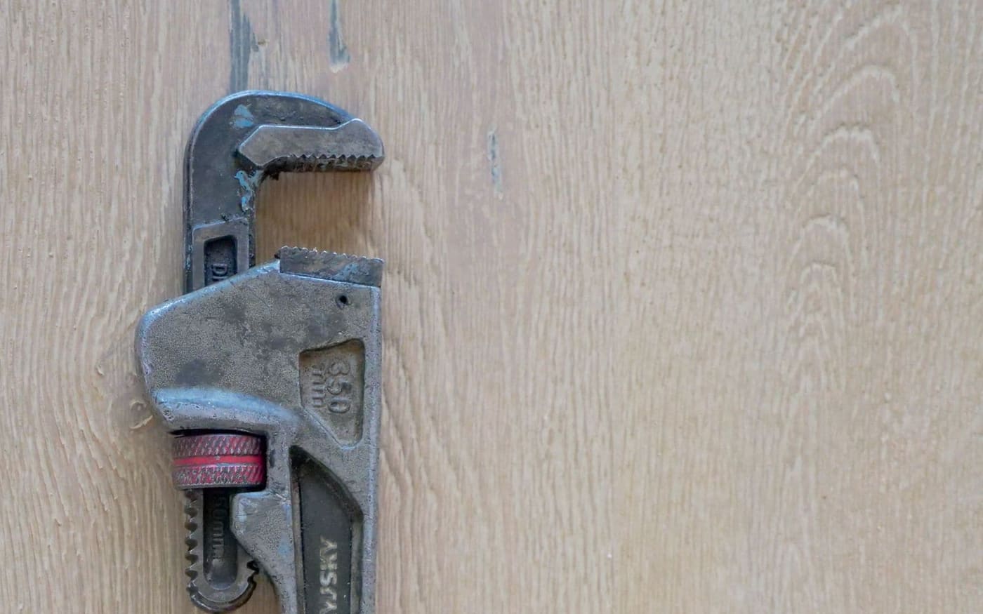 Heavy pipe wrench, the tool used to make and break the threaded connections on a water heater