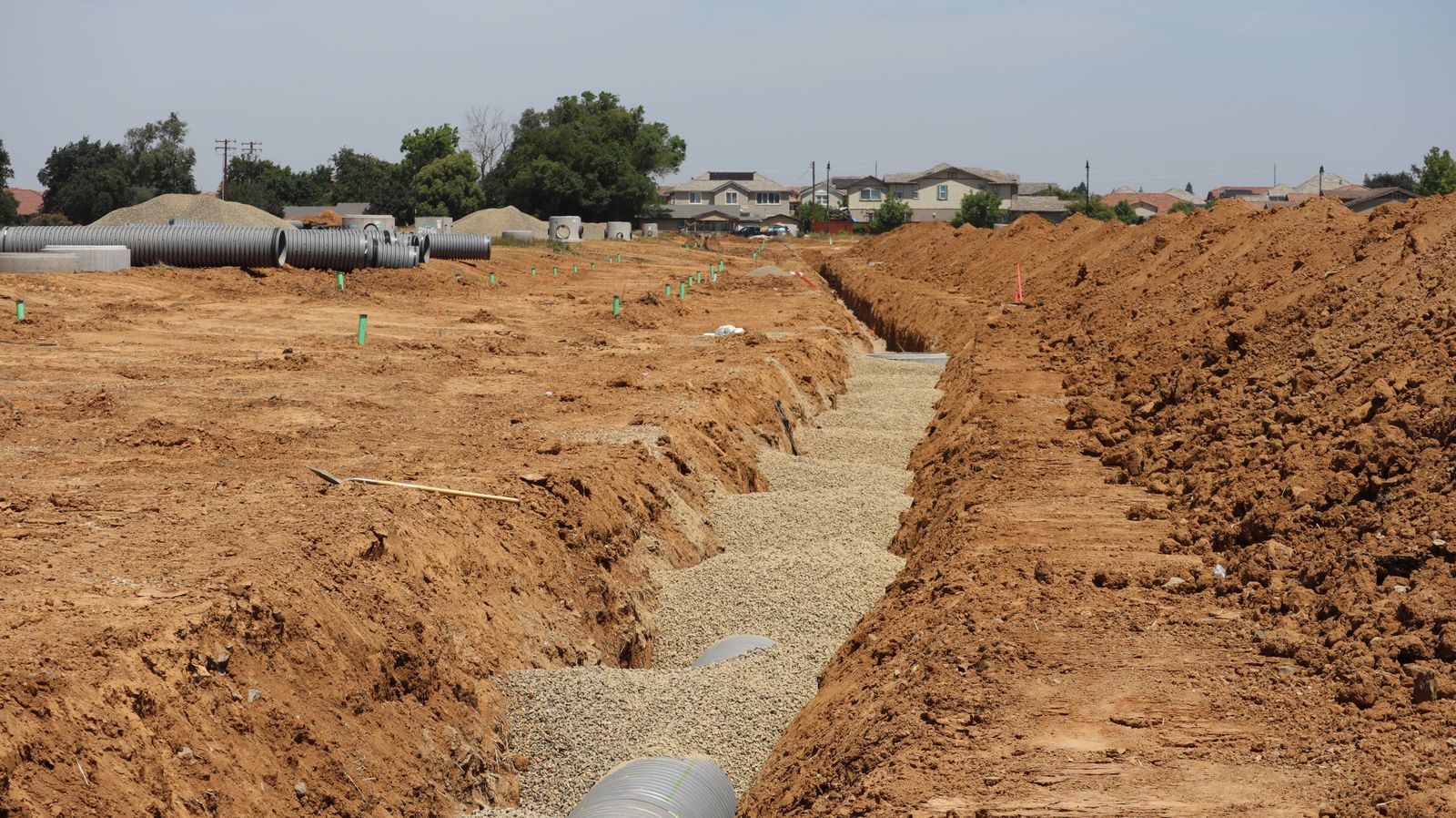 Suburban sewer work site showing the minimal excavation access pits used for trenchless sewer repair in Wilmington NC